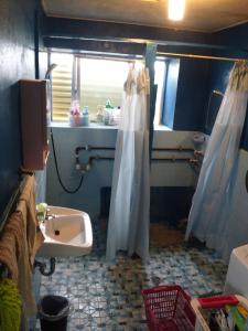 a bathroom with a sink and a shower curtain at Guest House Miyakojima in Miyako-jima