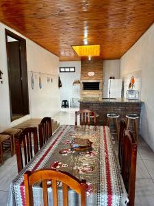 a dining room with a table and chairs and a kitchen at Casa Beira Mar com Piscina in Rio Grande