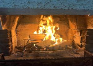 a fire in a brick oven with a bench in it at Appartamento 135mq - Splendida Vista Sul Lagorai in Cavalese