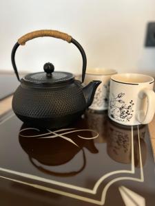 a black tea kettle and a cup on a table at Le soleil levant plage , casino, thalasso in Bénodet