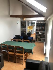 a living room with a table and chairs and bookshelves at Meadow Brook Gites in La Lande-de-Goult