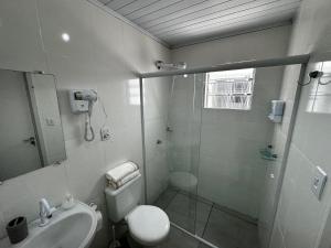 a bathroom with a shower and a toilet and a sink at Casa Beira Mar com Piscina in Rio Grande +4 photos