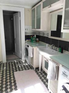 a kitchen with a sink and a washing machine at Maris Greek House in Konak