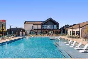 a swimming pool with lounge chairs and a building at Central Escape Gym, Coffee Bar, Perfect Location in Pflugerville