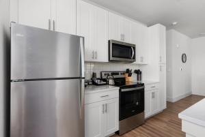 a kitchen with a stainless steel refrigerator and white cabinets at Central Escape Gym, Coffee Bar, Perfect Location in Pflugerville