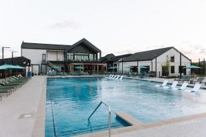 a large swimming pool with chairs and a building at Central Escape Gym, Coffee Bar, Perfect Location in Pflugerville +21 photos