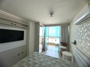 a bedroom with a bed and a flat screen tv at Apartamento Luxo Vista Mar Andrei Noriller in Arraial do Cabo