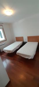 two beds in a small room with a window at EnSAN CIPRIAN Playas y Gastronomía in San Ciprián +22 photos