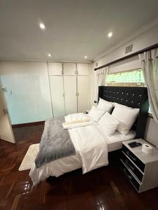 a bedroom with a large bed with white pillows at K-Lodge in Pietermaritzburg