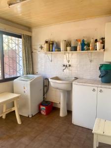 a kitchen with a sink and a white refrigerator at Casa en Mar del Plata - Colinas de Peralta Ramos in Mar del Plata