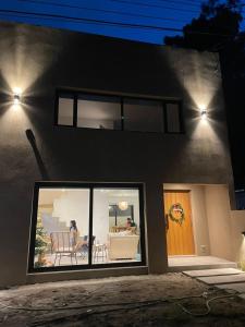 a house with a window and a person sitting on a couch at Senderos del Mar in Monte Hermoso