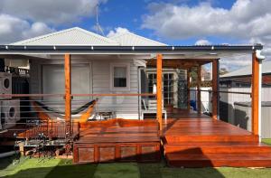 a house with a wooden deck on the yard at Rosebeach in Rosebud