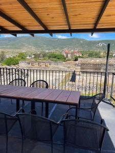 a wooden table and chairs on a balcony with a view at Casa Aida in San Pablo Villa de Mitla