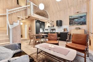 a living room with a staircase and a table and chairs at Cathedral Lodge in Tromsø