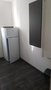 ein kleiner weißer Kühlschrank in einer Zimmerecke in der Unterkunft Appartement Le Beach31 à 200m de la plage, 1 chambre in La Guérinière