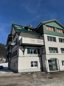 a large white building with a green roof at Loetje in Gosau