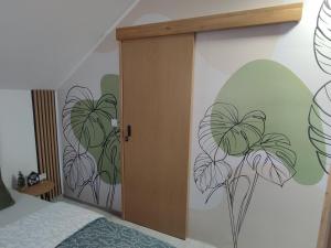 a bedroom with a door with flowers painted on the wall at Studio apartman Čolić - Kupres in Kupres