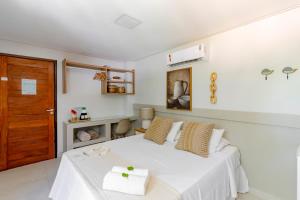 a bedroom with a white bed and a wooden door at Pousada Praiana in Porto De Galinhas +28 photos