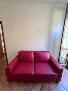 a red couch sitting in a living room at Aselli Palace in Cremona