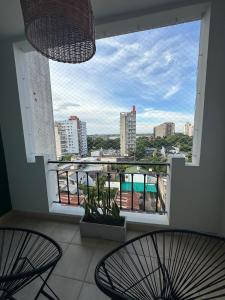 a balcony with two chairs and a view of a city at Departamento Junín 4 Bitcoins House in Corrientes