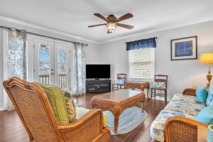 a living room with a couch and a tv at Blue Fish Shack by Oak Island Accommodations in Oak Island