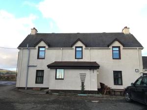 a white house with a black roof at Farmhouse in Clydebank