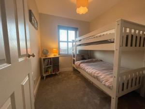 a bedroom with two bunk beds and a window at Peaceful Portstewart pad in Portstewart
