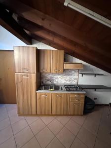 a kitchen with wooden cabinets and a stove at Dante 13 Flat in Cremona