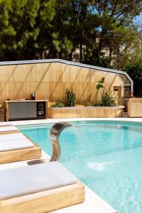 カリロにあるLa Galeria - Hotel Boutique Carilóのフェンスの前に2つの長椅子があるプール