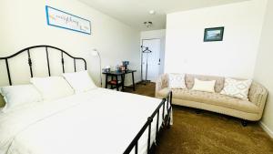 een slaapkamer met een bed en een bank bij Double room-wake up to stunning sunrises, unwind magical sunsets in Tacoma