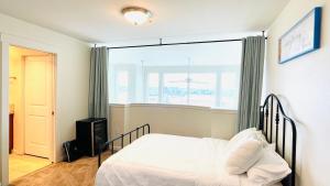 een slaapkamer met een bed en een groot raam bij Double room-wake up to stunning sunrises, unwind magical sunsets in Tacoma