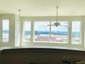 een kamer met 3 ramen en een plafondventilator bij Double room-wake up to stunning sunrises, unwind magical sunsets in Tacoma +11 foto's