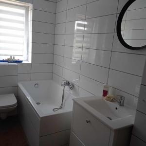 a white bathroom with a tub and a sink at Przystań in MaryLin