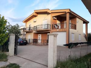 a house with a dog sitting on a balcony at Apartments Visar in Ulcinj