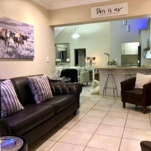 a living room with a couch and a kitchen at #SilverSands Coastal Retreat in Betty's Bay in Bettyʼs Bay +37 photos