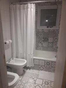 a bathroom with a toilet and a tub and a sink at Sierra Bonita - Viví en Armonía in Sierra de los Padres