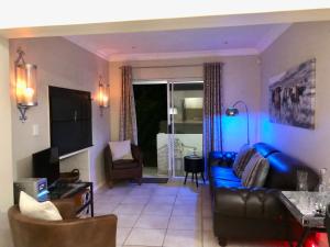 a living room with a blue couch and chairs at #SilverSands Coastal Retreat in Betty's Bay in Bettyʼs Bay +37 photos