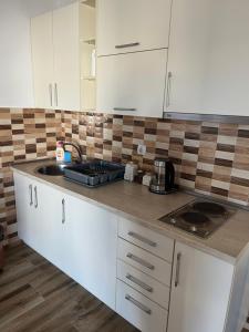a kitchen with white cabinets and a sink at Apartments Visar in Ulcinj +3 photos