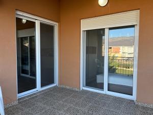 two sliding glass doors on the side of a building at Apartments Visar in Ulcinj