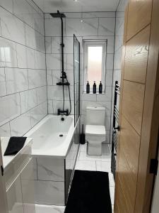 a white bathroom with a tub and a toilet at Galway Glamour in Bircotes +11 photos