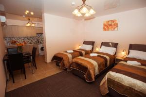 a hotel room with three beds and a kitchen at Apartamentai Vyta in Klaipėda