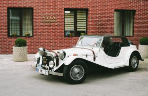 an old white car parked in front of a brick building at Apartamentai Vyta in Klaipėda