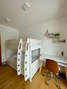 una camera da letto con un letto a castello e una scrivania di Apartma Gorna a Kranjska Gora Altre 4 foto