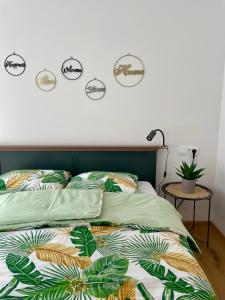 una camera da letto con un letto con lenzuola e piante verdi di Apartma Gorna a Kranjska Gora