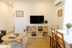 a living room with a flat screen tv on a white cabinet at Cozy Downtown Havens in Moscow