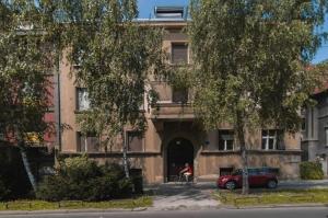 ein Gebäude mit einem roten Auto, das davor geparkt ist in der Unterkunft Apartment Ive in Zagreb