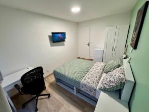 a bedroom with a bed and a desk and a chair at York's APPART in Saint-Herblain