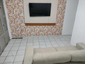 un soggiorno con un divano e una TV a parete di Jb casa temporada a Maceió