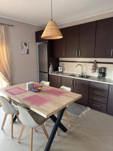 アレクサンドルポリスにあるZoe's Luxury Homes 2のキッチン(木製テーブル、椅子、シンク付)