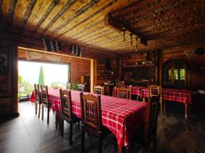 a dining room with a red table and chairs at Casa Șaru Bucovinei in Şaru Bucovinei